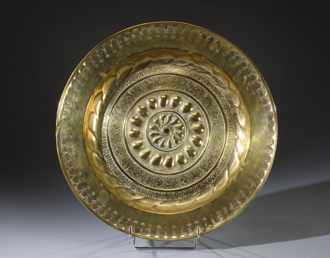 Null 黄铜制的供品盘，压印有小圆点，并印有花朵和字母。

17世纪，佛兰德斯。

D. 44厘米。

损坏和丢失的部件。