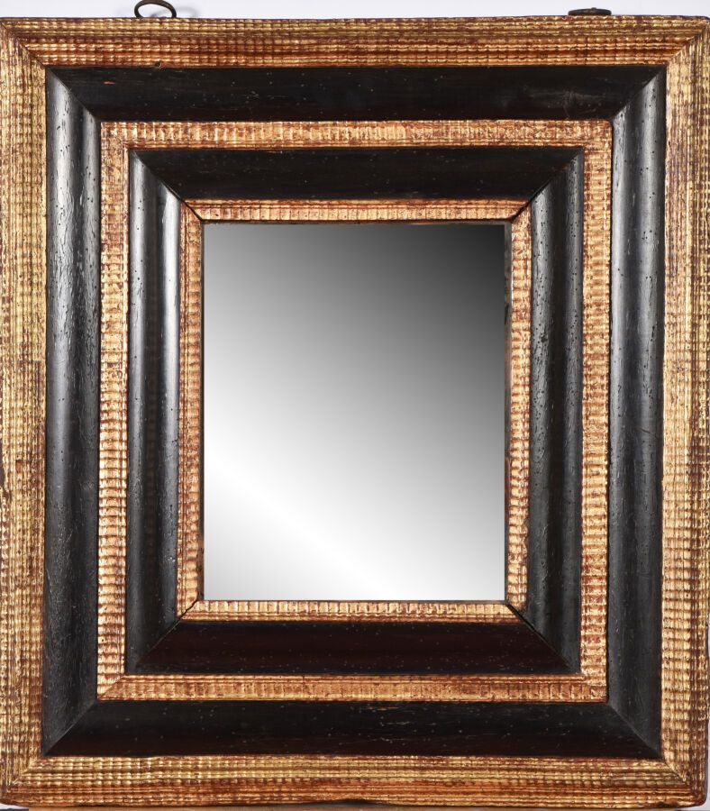 Null 一面涂黑和镀金的木制镜子，倒置的轮廓，用波浪形的杆子做框架。

17世纪。

63 x 57厘米。

事故、修复、镀金。