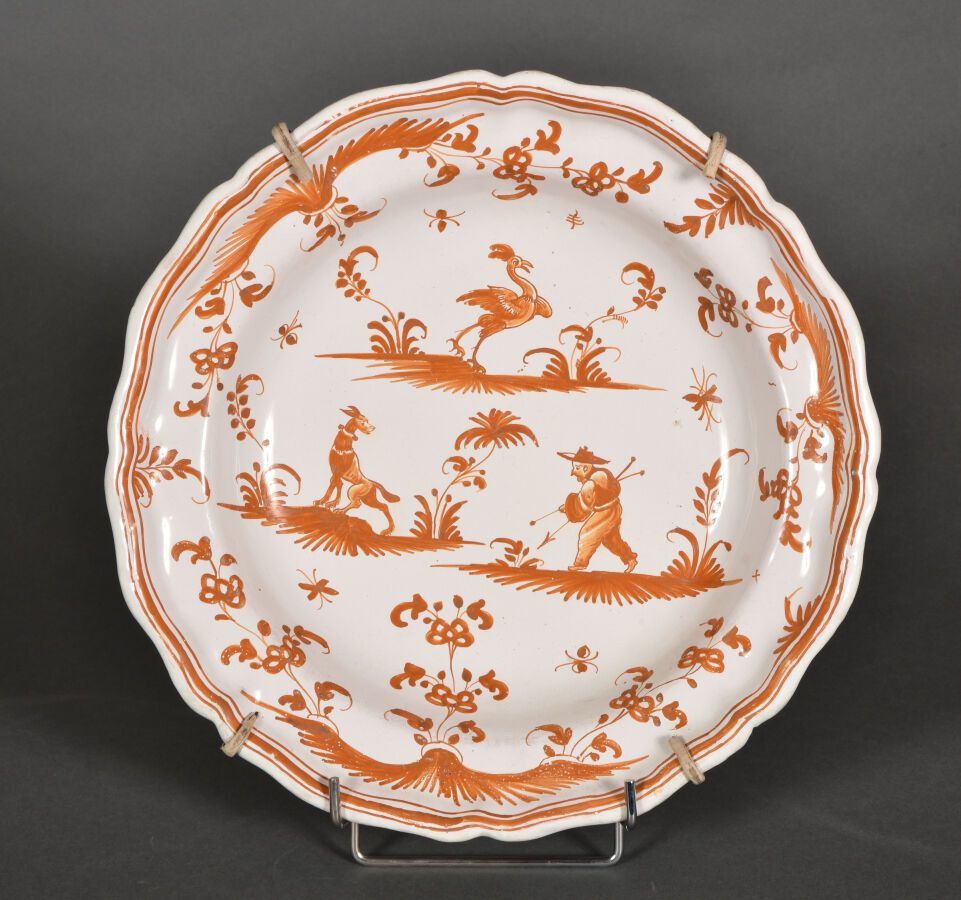 Null 慕斯人。

赭石色单色装饰的陶器圆盘，边缘有轮廓，上面有一个人物，一只狗和一只神奇的鸟在梯田和花丘上。

18世纪晚期。

D.35厘米。