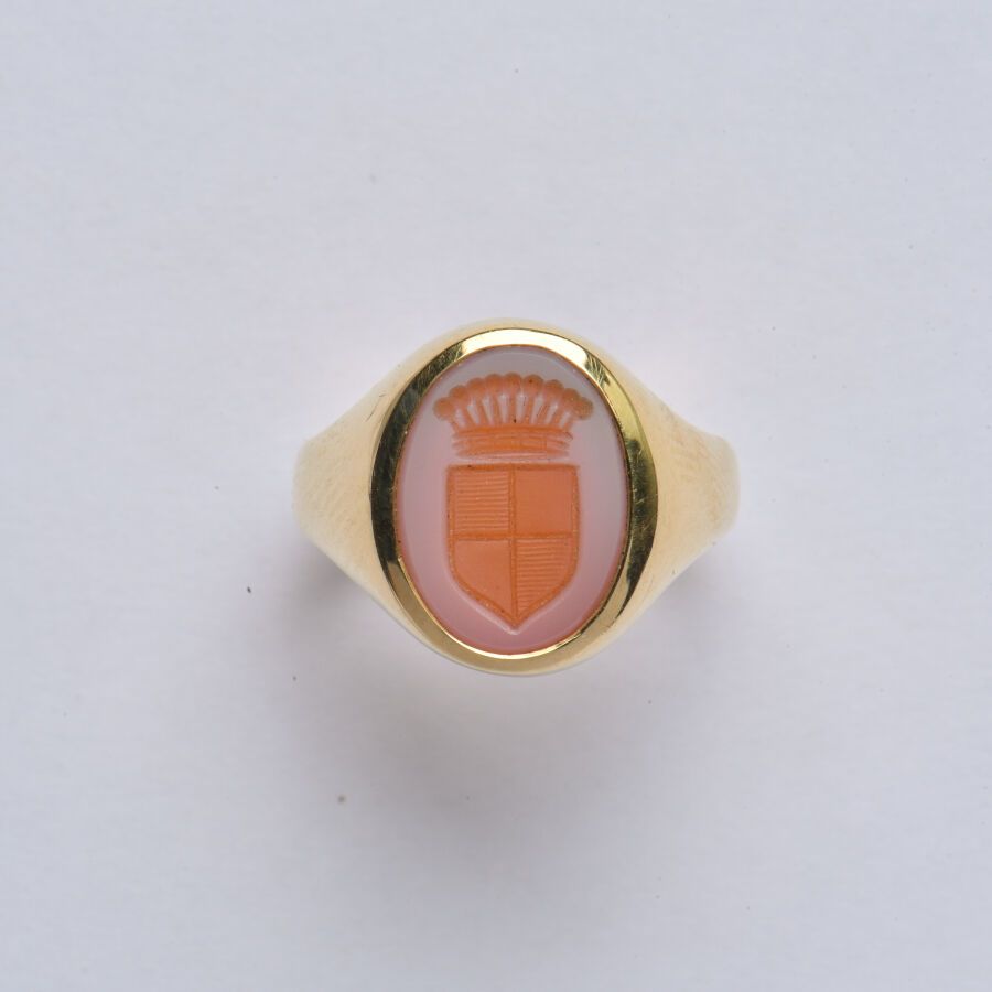 Null 一枚18K（750/oo）黄金骑士戒指，以双色红玉髓玛瑙凹刻的椭圆形板为中心，刻有纹章。TDD 48.毛重：6.7克。
