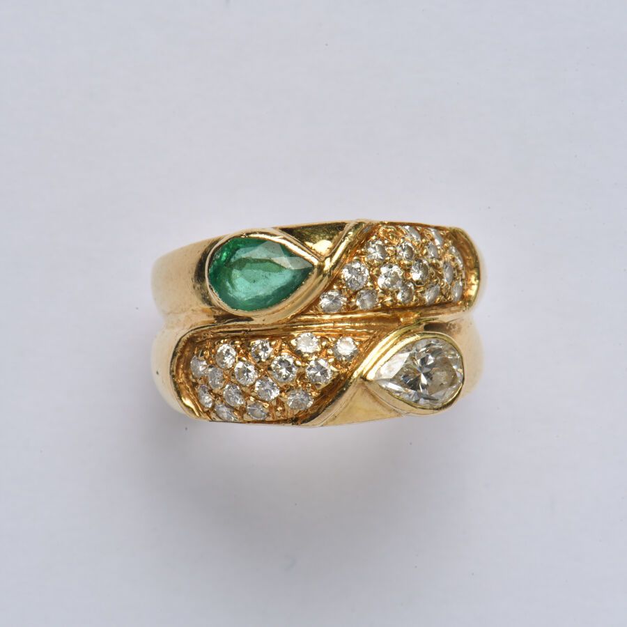 Null 一枚18K(750/oo)黄金戒指，由两个相邻的戒指组成，上面镶嵌有密镶钻石，并装饰有一颗重约0.50克拉的梨形钻石和一颗梨形祖母绿（已磨损并有一个小&hellip;