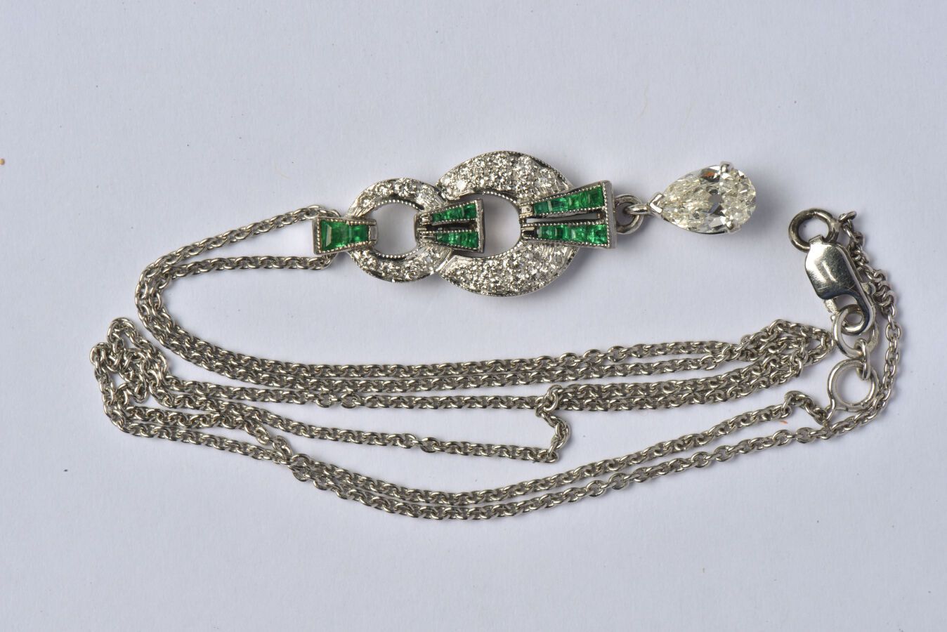 Null 18K（750/oo）白金吊坠，环形和条形的镂空装饰，镶嵌明亮式切割钻石和校准的祖母绿，它持有一颗约0.70克拉的梨形钻石。与其18K（750/oo）&hellip;