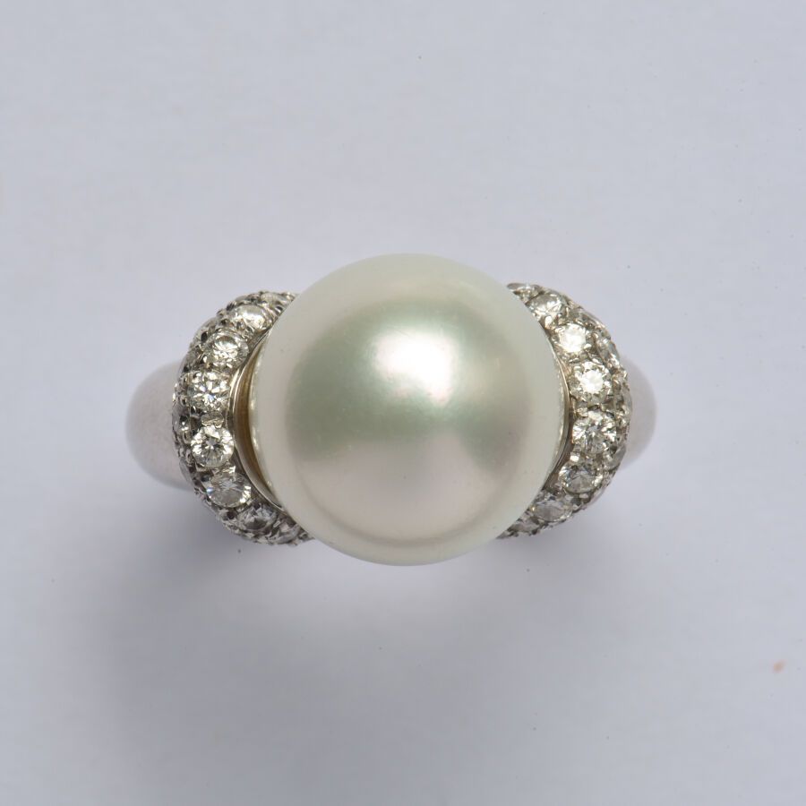 Null 一枚光滑的18K(750/oo)白金戒指，以一颗大的南海养殖珍珠（直径：约13.9毫米）为中心，由两个镶嵌明亮式切割钻石的弧形图案支撑。TDD 52.&hellip;