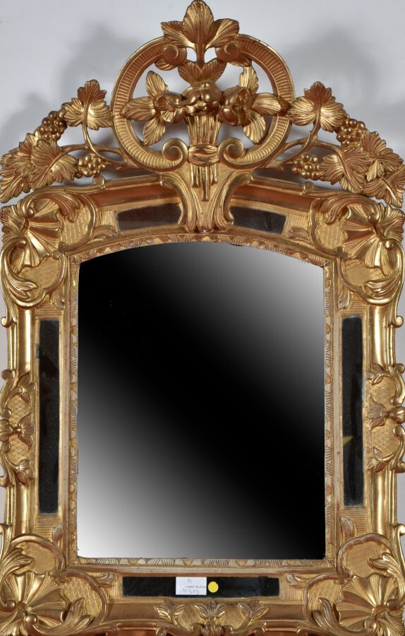 Null 一面带有镀金框架的木雕镜子，装饰着贝壳和叶子，踏板上有一个花束。 
18世纪。 
H.78厘米 - 宽51厘米。
事故，修复。