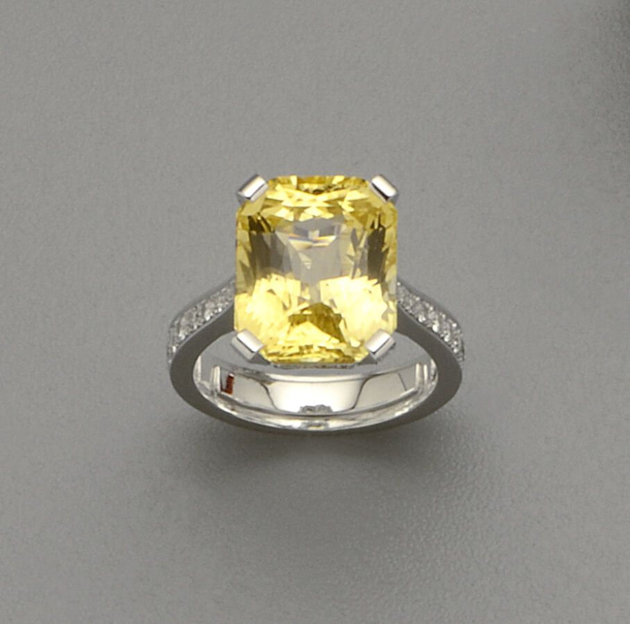 Null 18K（750/oo）白金戒指，以一颗重达13.50克拉的大型矩形切割黄色蓝宝石为中心（该宝石附有克拉宝石实验室证书，说明：未经处理的天然宝石，"鲜艳&hellip;