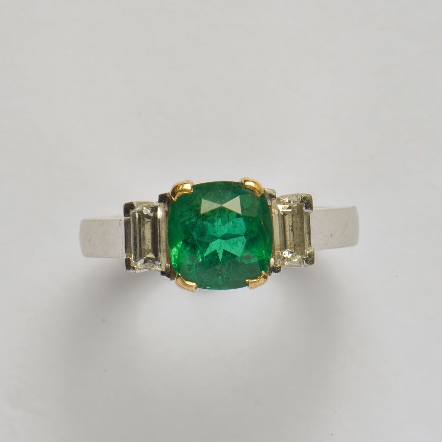 Null 一枚18K(750/oo)双色金戒指，以一颗重约2.15克拉的枕形祖母绿为中心（轻微的平齐裂纹），由两颗梯形切割钻石支撑。TDD 54。毛重：7.3克&hellip;