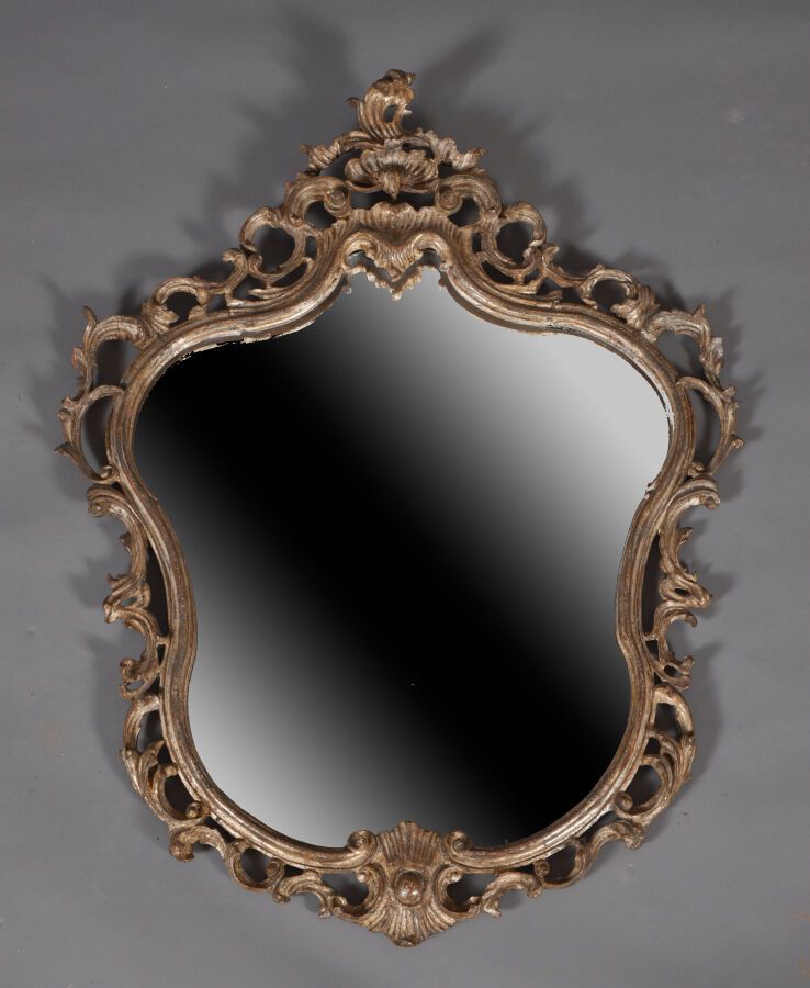 Null 一面镀银的护身符形式的木镜，雕刻着镂空的贝壳和卷轴。 
18世纪，意大利。 
H.96厘米 - 宽75厘米 
装饰物，修复物，添加的镜子。