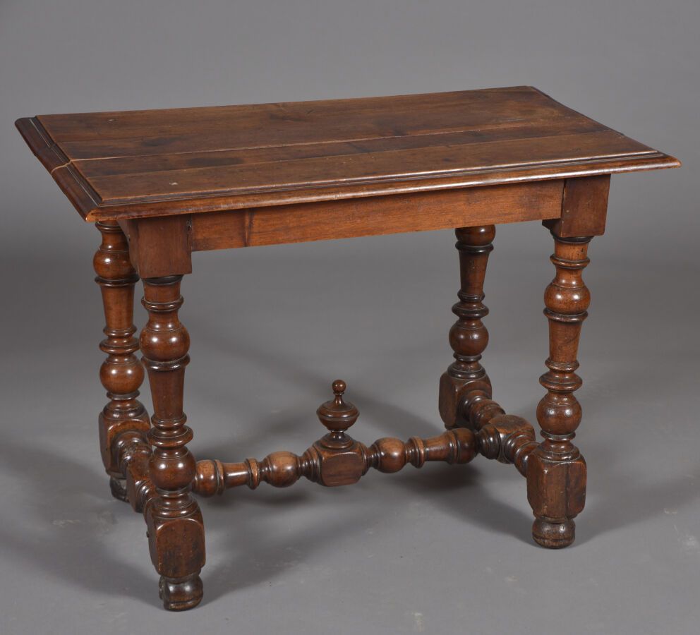 Null 胡桃木桌子，搁置在由一个H形支架连接的四条转动的栏杆腿上。 
17世纪末，18世纪初，里昂地区。 
H.69厘米 - 宽95厘米 - 深56厘米 
损&hellip;