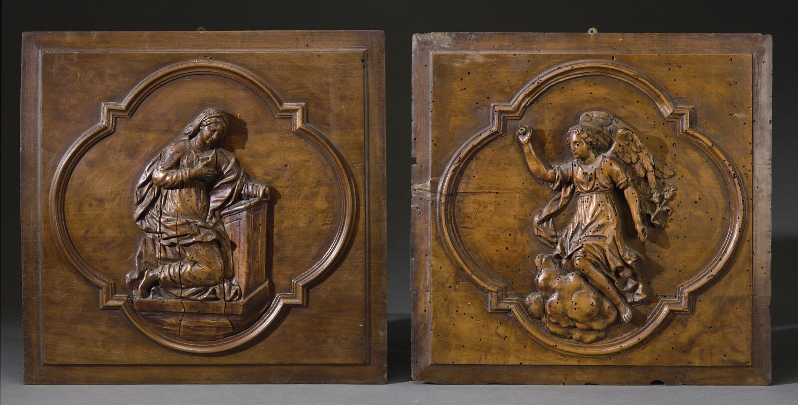 Null 两块天然木雕的挂板，描绘了圣米迦勒和一个正在祈祷的圣人，位于四叶形包围的面板上。 
尺寸：40 x 41厘米 
18世纪。 
装饰和修复。