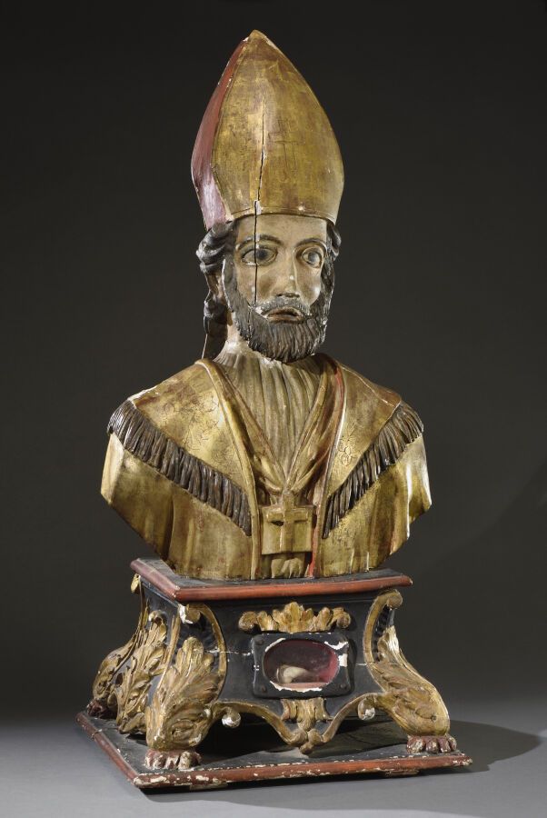 Null 雕刻、镀金和多色的木制主教灵位，描绘了一个主教的半身像，在一个装有遗物的叶状台灵位上。 
17世纪末，18世纪初。 
H.105 cm - L. 48&hellip;