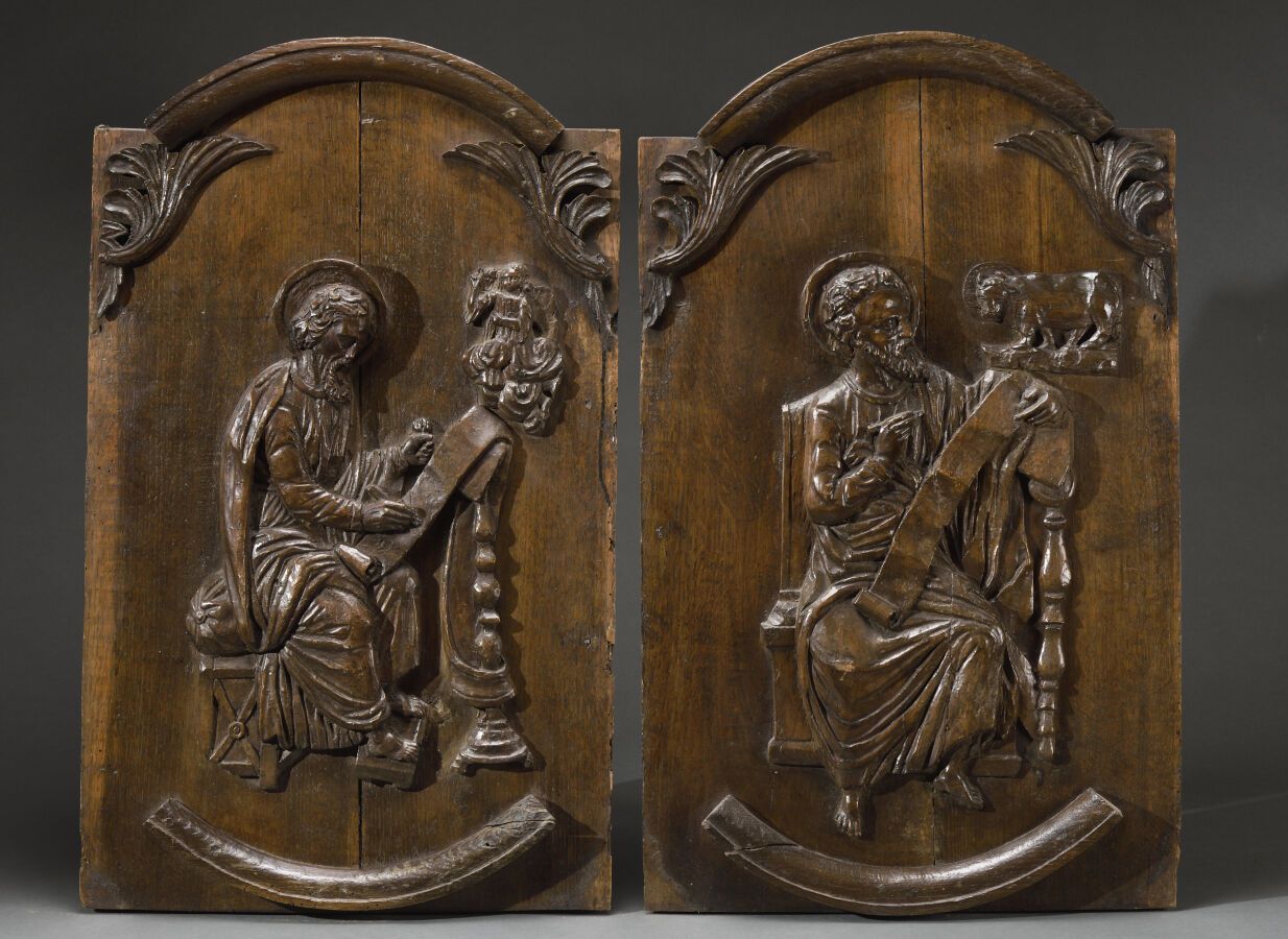 Null 两块橡木雕花挂板，描绘了福音书作者圣路加和圣马太以及他们的属性。 
18世纪初。 
H.75 cm - W. 45 cm 
损坏和修复。