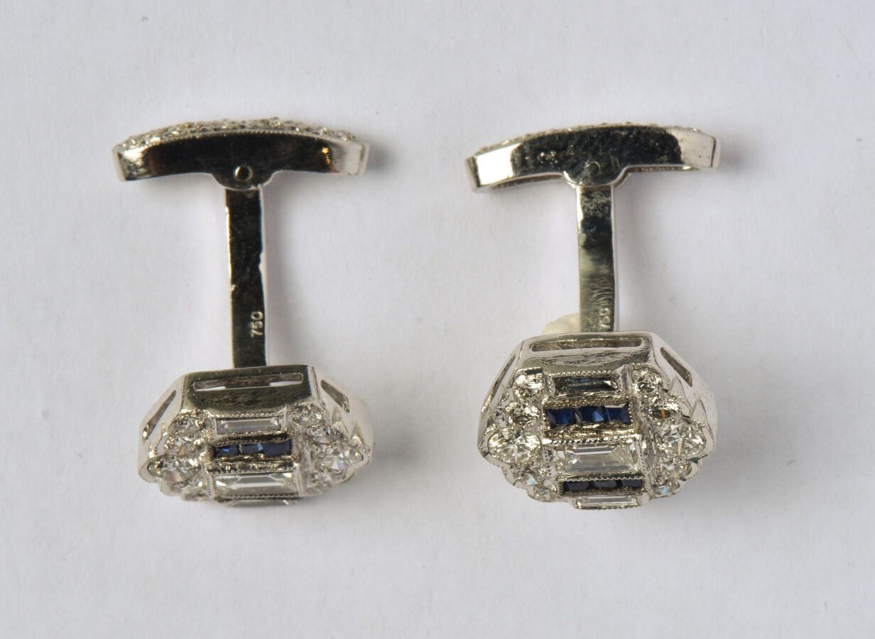 Null 一对18K（750/oo）白金袖扣，图案镶嵌了明亮型切割钻石和校准蓝宝石，摇摆系统镶嵌了多条明亮型切割钻石。毛重：10.6克。
