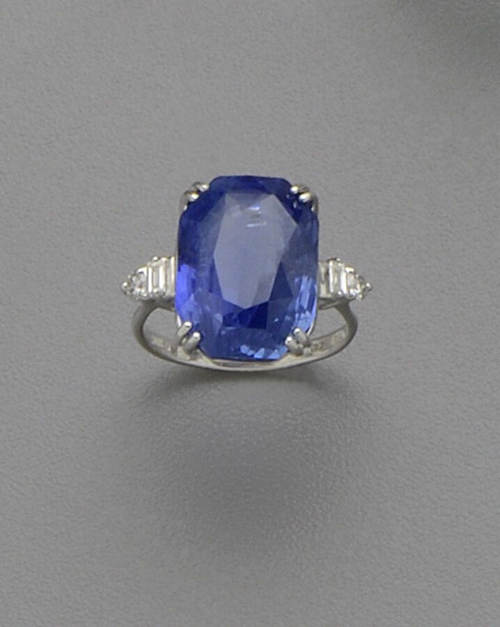 Null 18K（750/oo）白金戒指，镶嵌一颗八角形蓝宝石，重14.40克拉，原产于锡兰，未经热处理，镶嵌明亮式切割和长方形切割钻石。该宝石附有宝石学证书。&hellip;