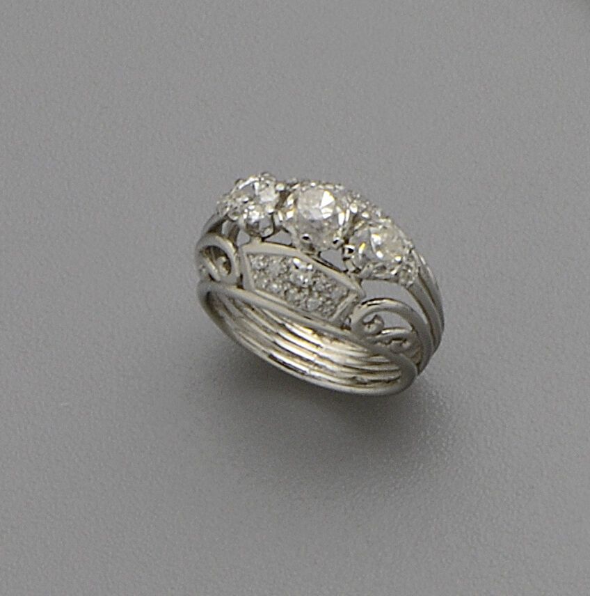 Null 铂金（850/oo）线环，镂空的卷轴设计以一排老式切割的枕形钻石为中心，主钻石的尺寸约为1 x 0.80克拉和2 x 0.50克拉，并镶嵌有密镶老式切&hellip;