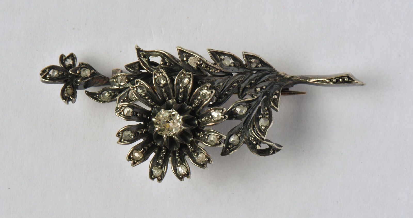 Null 古董银质胸针（800/oo）的特点是茎上有一朵玫瑰花，镶嵌着玫瑰式切割的钻石（缺2颗），花的中心是一颗老式切割的钻石，约0.20克拉。胸针为18K（7&hellip;