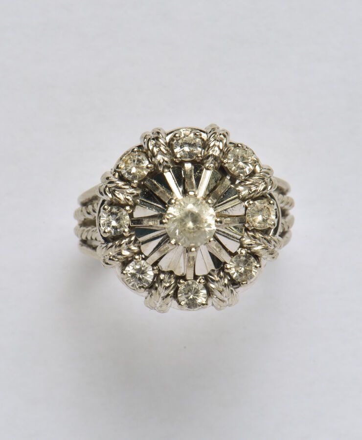Null 18K(750/oo)白金戒指，镂空的玫瑰花形顶部镶嵌着仿白宝石（已磨损），扭线的附件。TDD 53。毛重：6.5克。