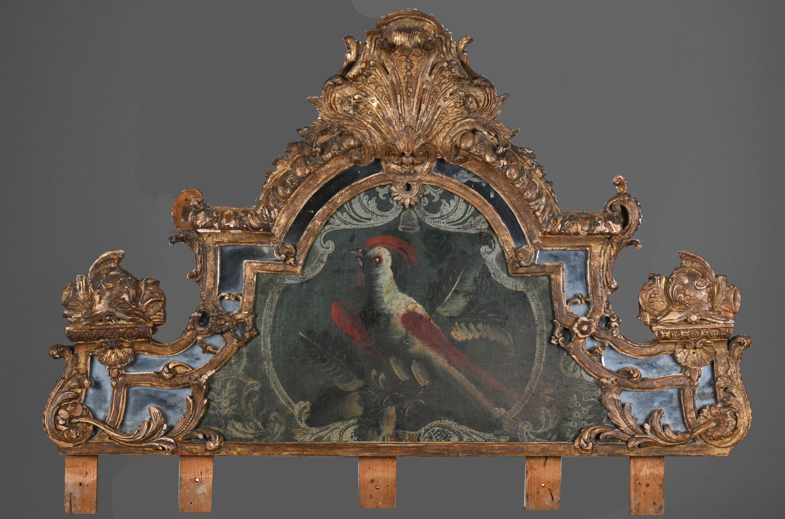 Null 木质雕刻镀金镜面花饰，饰有贝壳、头盔、贝壳和花朵，中央画有一只异国鸟。
摄政时期
H.73 - 102 厘米
装饰、修复