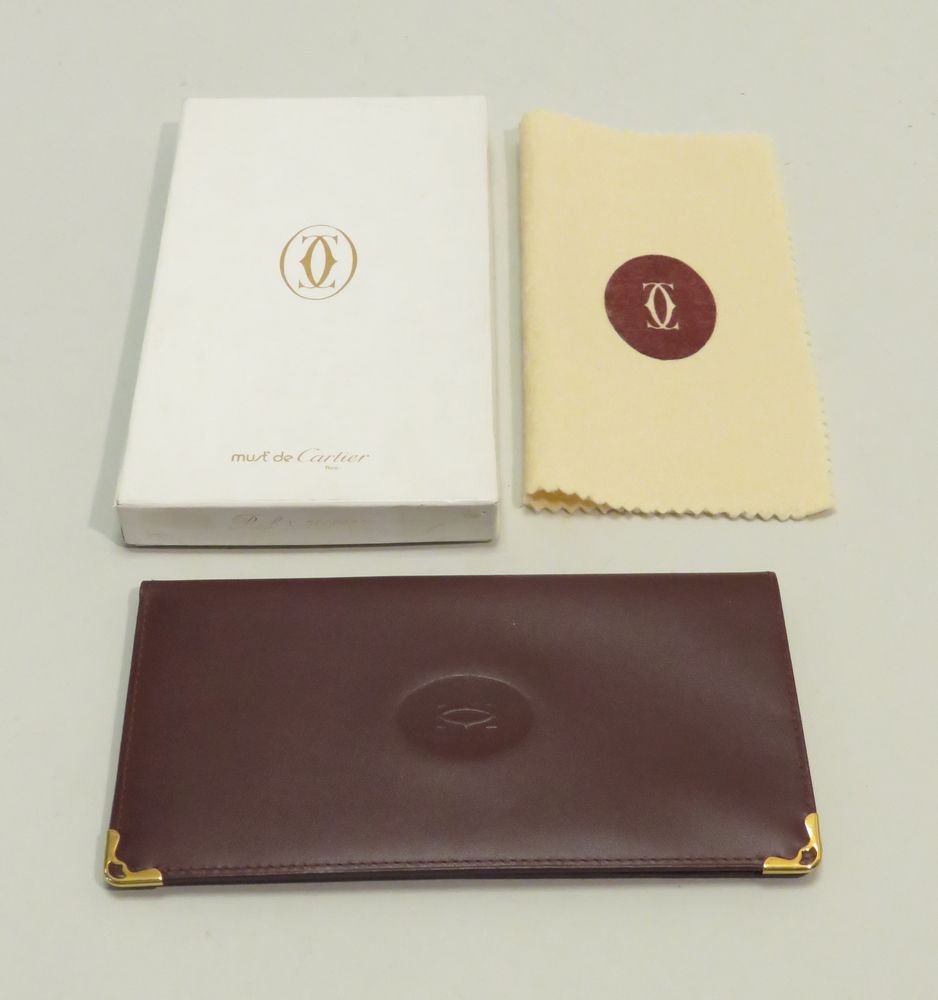 Null 卡地亚，巴黎。皮革和镀金的金属钱包。原装盒，有保修卡（全新状态）。18 x 9,5厘米（折叠）。