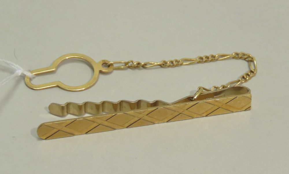 Null 带链子的黄金领带针。净重：3克75。长度：4.5厘米（针）。