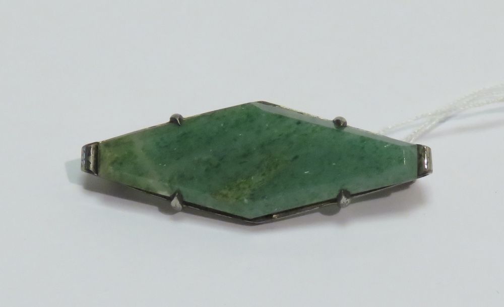 Null Silver brooch supporting a green stone carved in rhombus. Circa 1930. Gross&hellip;