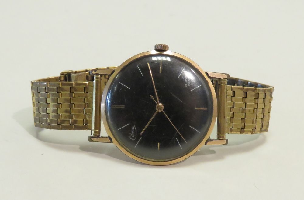Null EDMA。镀黄金的男士腕表。表盘有一个黑色的背景，玻璃是弯曲的。金属镀金的手镯（非原装）。机械绕线运动（工作）。