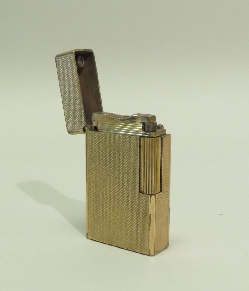 Null S.T.DUPONT，巴黎。镀黄金口袋打火机，带玑镂装饰（工作）。6 x 3,5 cm。