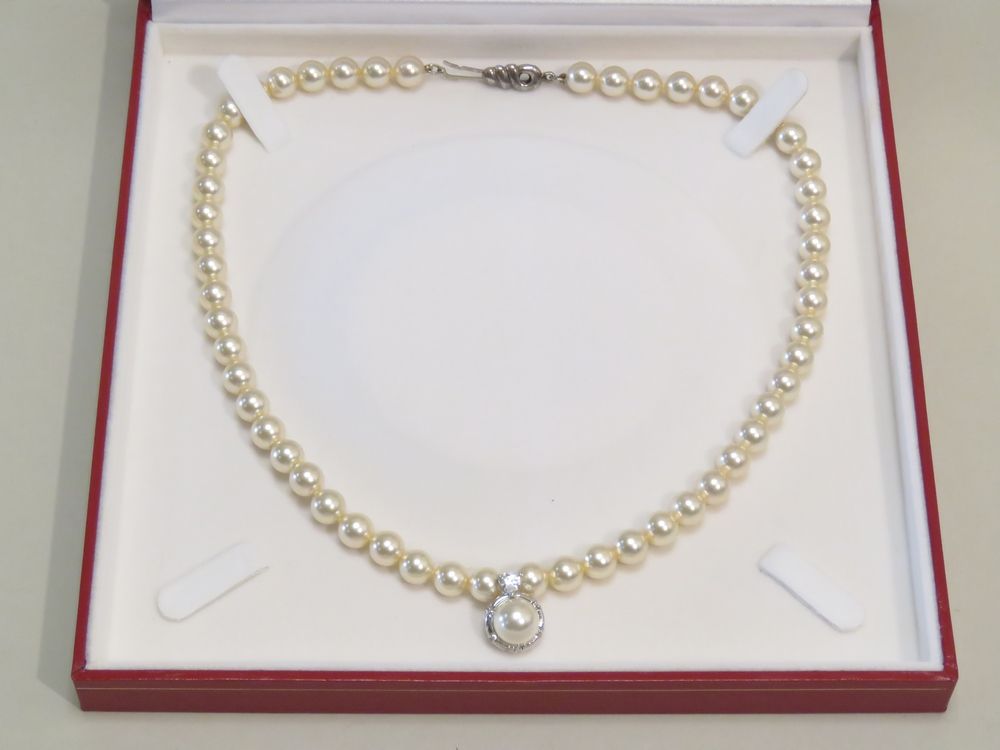 Null 花式珍珠项链，吊坠在金属环上镶嵌了一颗合成珍珠，并镶有一颗花式心形钻石。带钩的银扣。长度：48厘米。附有一个盒子。