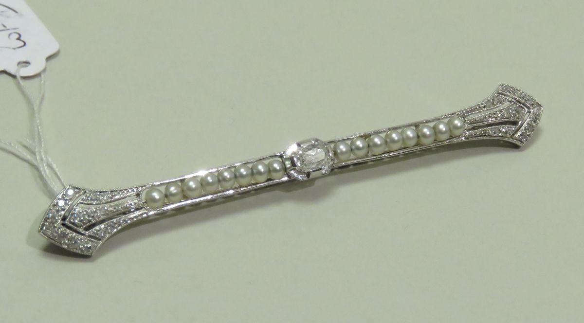 Null 美丽的白金胸针，精细的镂空，镶嵌着一颗约0.25克拉的枕形钻石，胸针的两端镶嵌着28颗小圆钻，并以一排小淡水珍珠充实。ART DECO时期。毛重：5g&hellip;