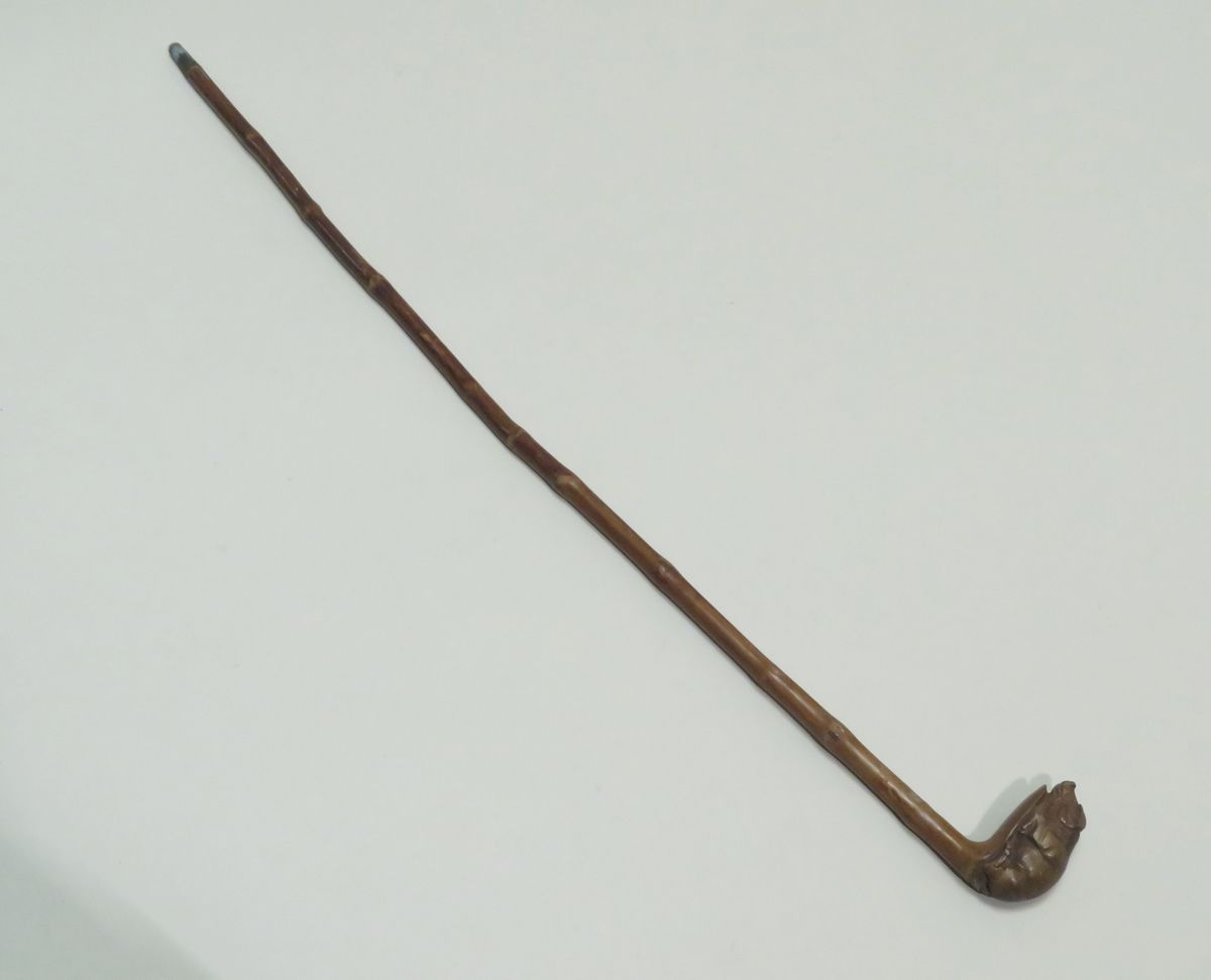 Null Cane in rattan for child, the knob carved of a pig. Length : 67 cm.