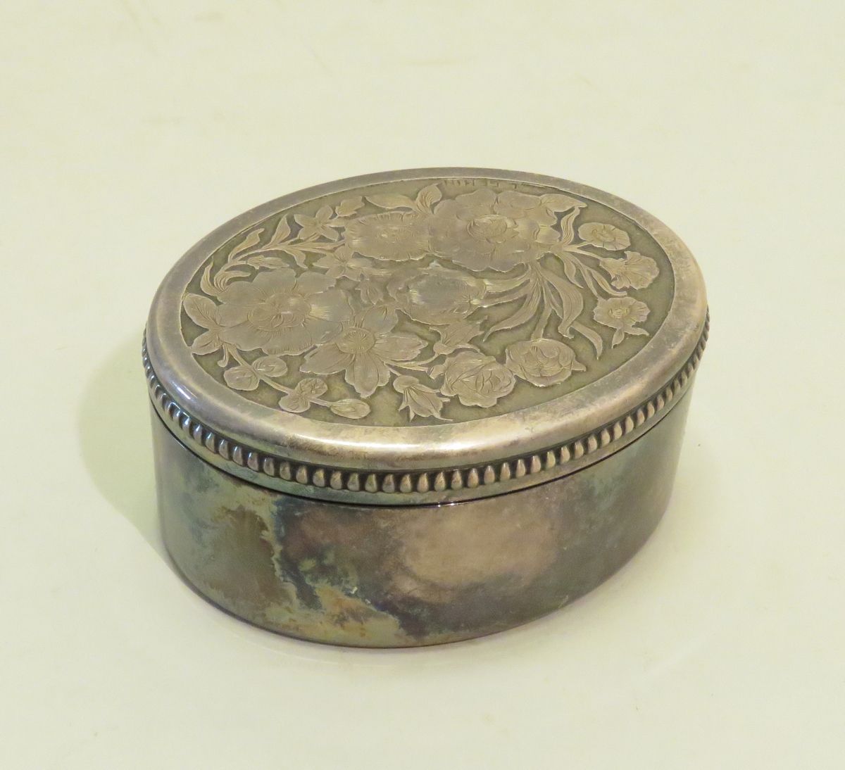 Null L.GENIN (XIX-XXème).银色金属盒（盖子上部分没有银色），有风格化的花卉装饰。签名：5 x 10 x 8 cm。