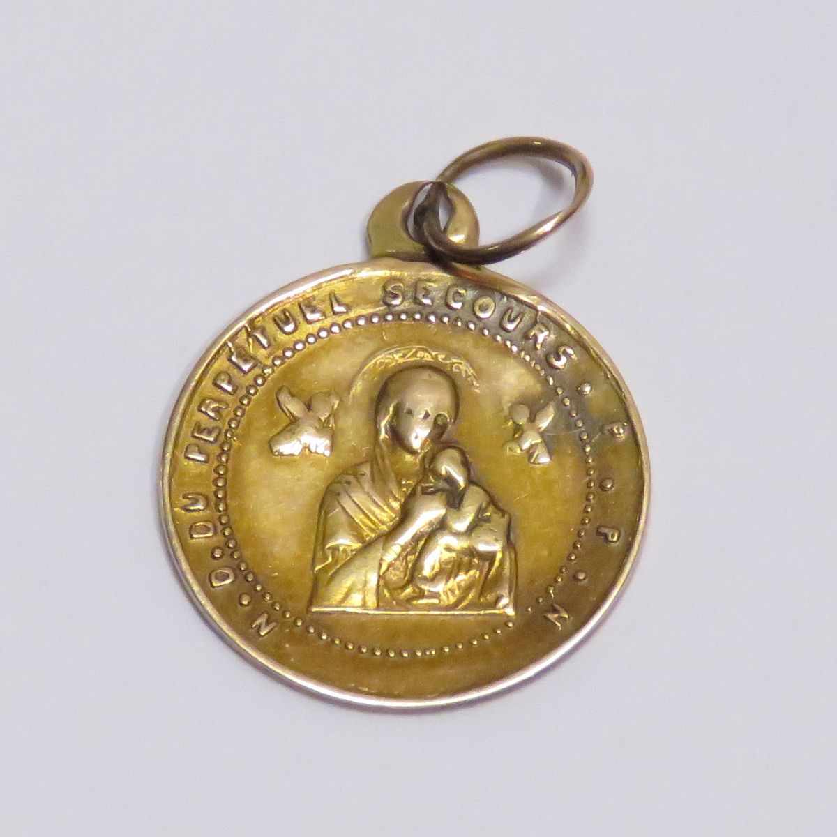 Null 一枚18K黄金的出生/洗礼纪念章，正面是圣母和儿童耶稣，背面是圣阿方索-玛丽-德-利古里。净重：0克85。直径：2厘米。