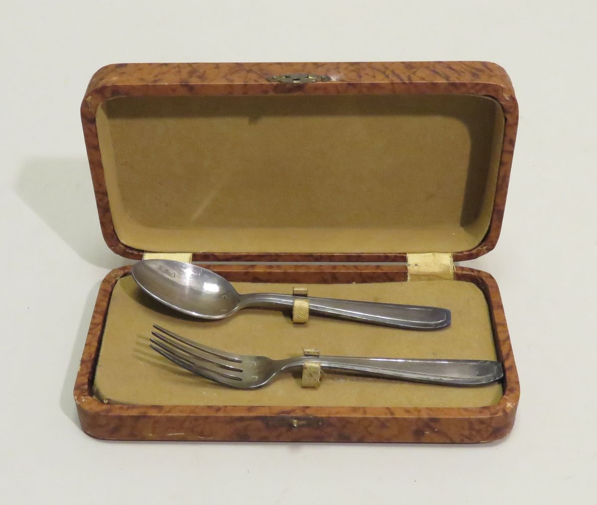 Null 一个镀银金属的儿童餐具（2件）。长度：14厘米。在原来的盒子里。