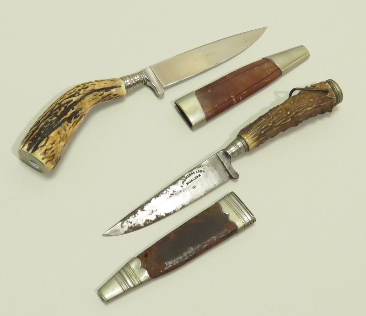 Null Deux couteaux de chasse.
Poignées en bois de cerf. Montures en fer poli. Fo&hellip;