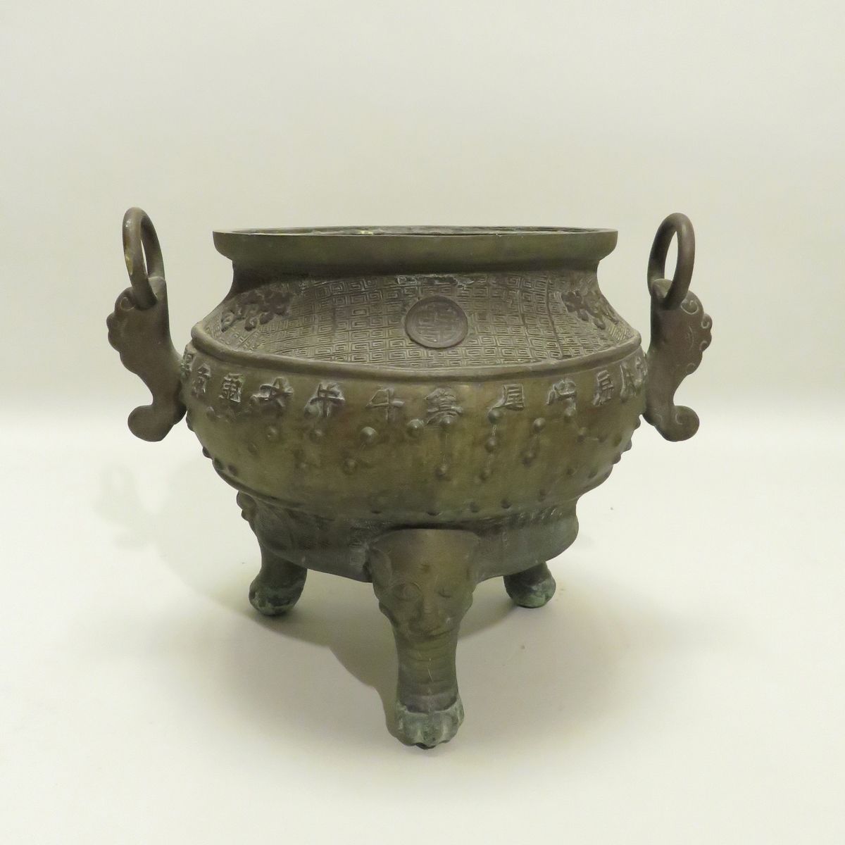 一件中国古代丁字形的青铜鼎香炉，炉身以浮雕的方式装饰着以名字标识的