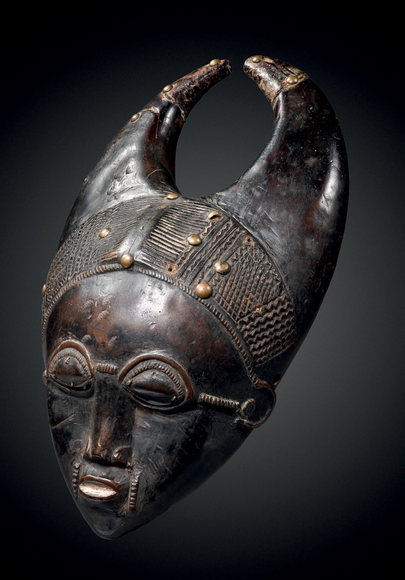 Null Maske, Baule, Elfenbeinküste
Holz mit brauner Patina und Abnutzung, Melknäg&hellip;