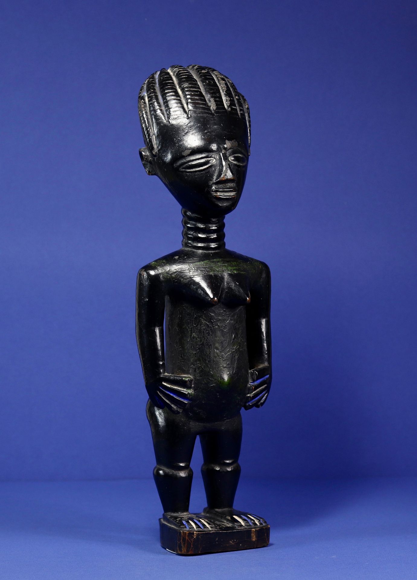 Null 
雕像代表一个站立的女性形象，手臂与身体分离，双手放在臀部，腿很短，方肩，颈部有环，头部戴着辫子头饰。 



带有黑色铜锈的木头，有多色的痕迹。 
&hellip;