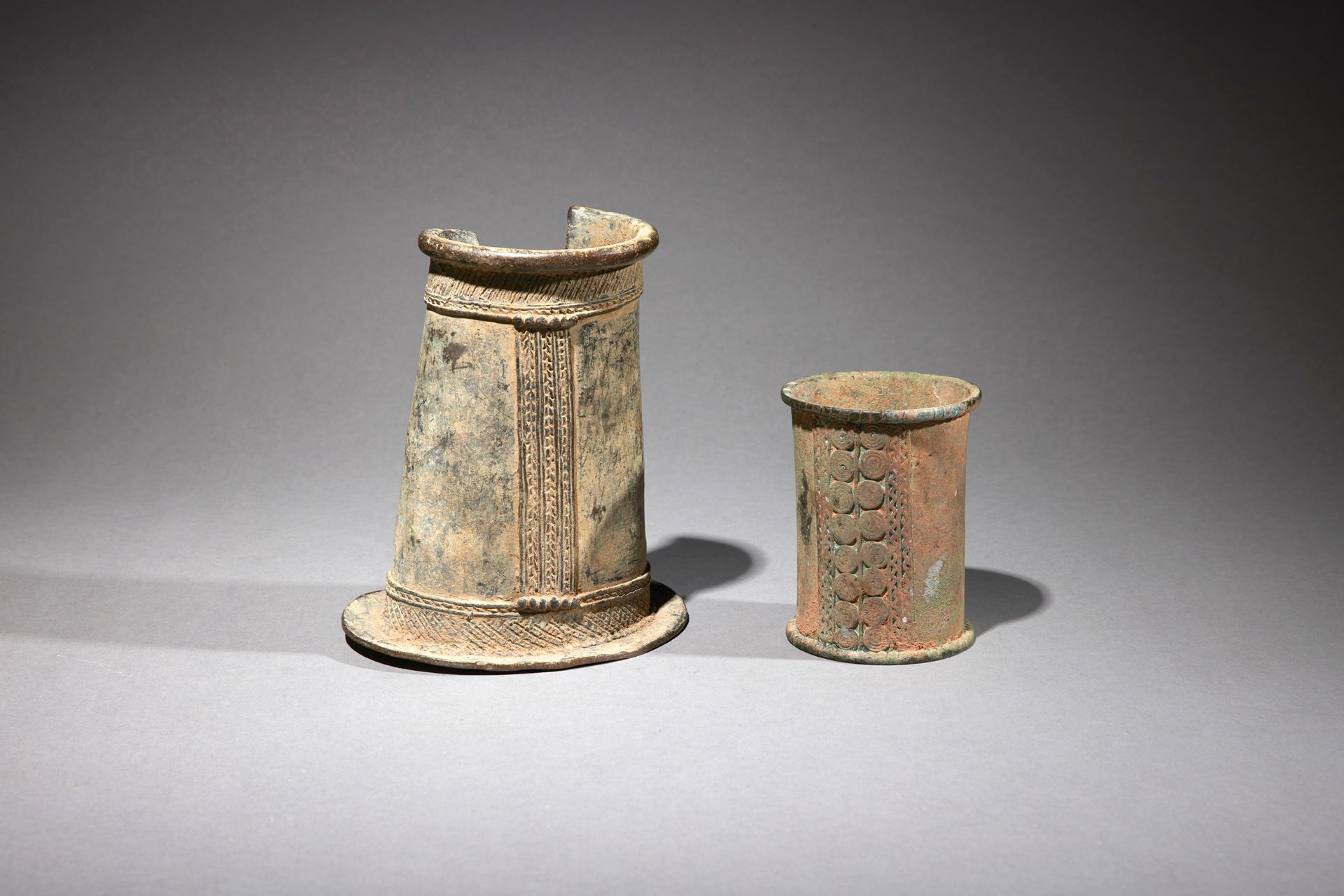Null 两个装饰品

西非

铜质

H.10和16厘米



一套两个饰品：一个脚链（Gurunsi?）和一个青铜手镯。表面上出现了浮雕式的几何装饰。