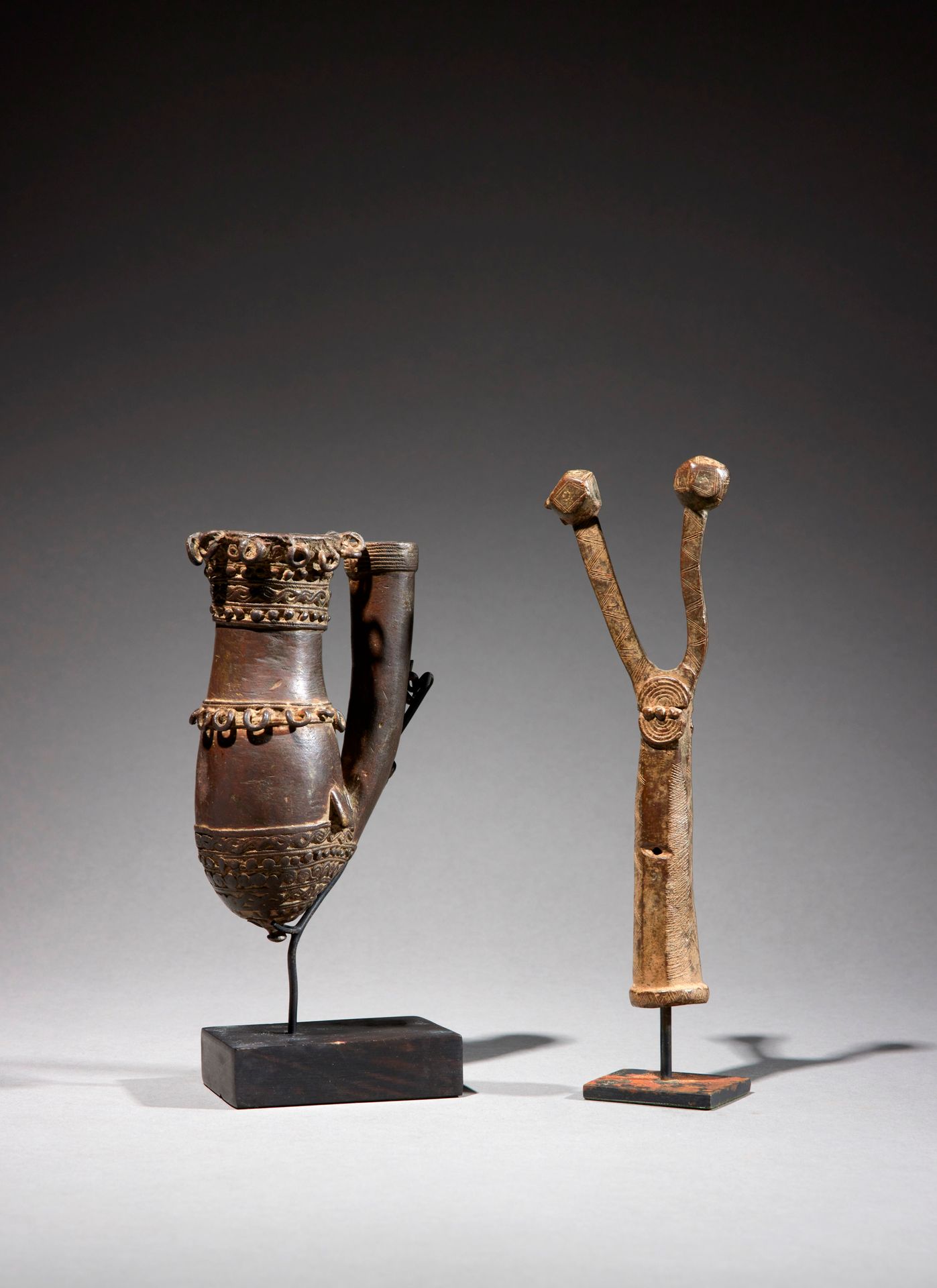 Null 两件人工制品

尼日利亚

铜质

H.14至19厘米



一套两件青铜器：包括一个美丽的Nupe烟斗和一个以两点结束的权杖顶。
