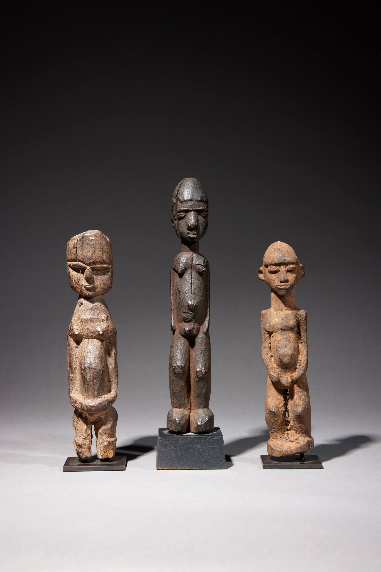 Null 三个洛比雕像

布基纳法索

木头

H.16至19.5厘米



一套三件雕像，代表站立的人物，根据洛比雕像的准则进行描绘，覆盖着仪式性的锈迹。