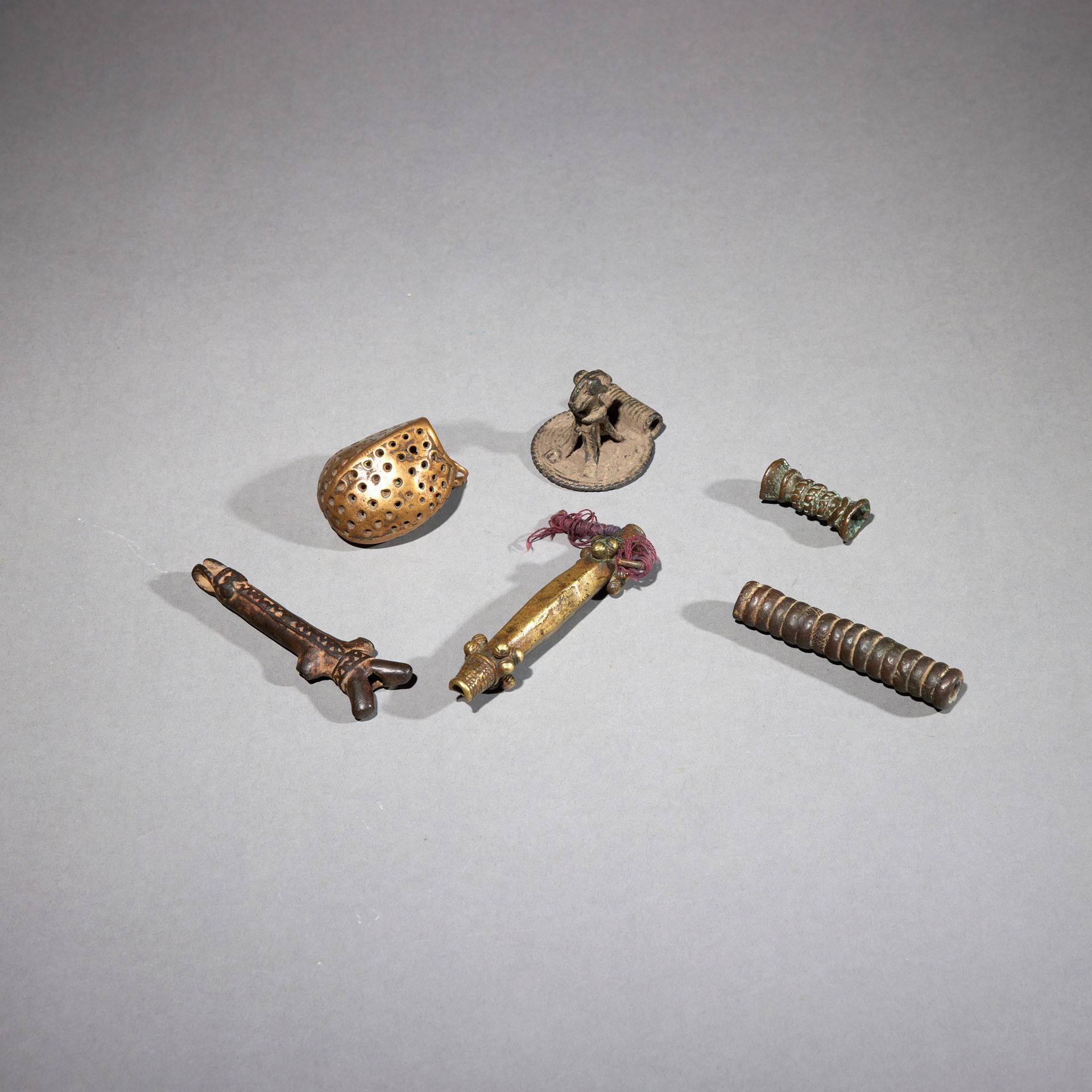 Null 六件人工制品

象牙海岸/布基那法索

铜质

长3.5至9.6厘米



一套六件青铜器，包括两个管状珠子和四个吊坠，包括一个哨子。