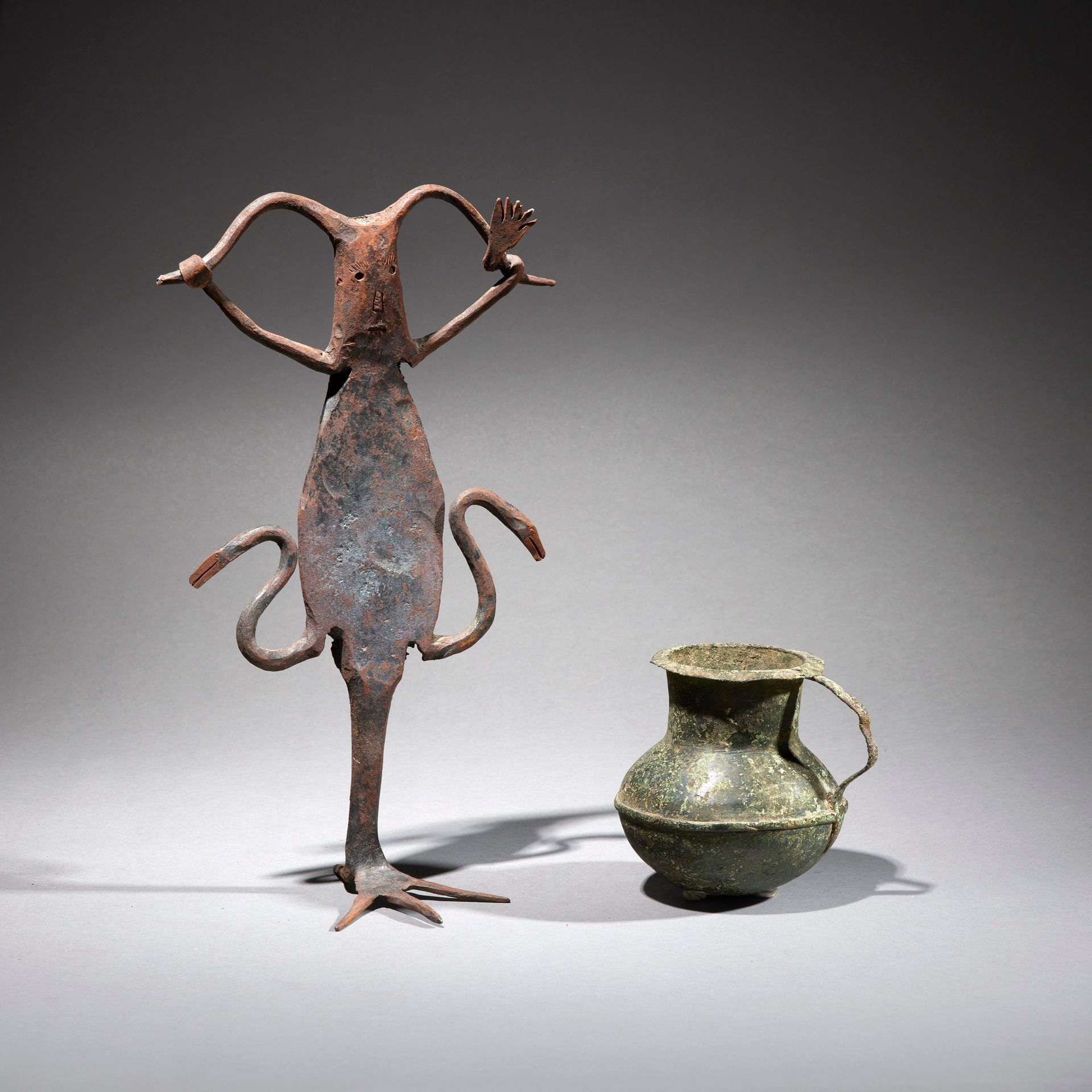Null 两件人工制品

西非

青铜，铁

H.10.5和31.3厘米



一套两件青铜器，包括一个铁制的伏都教雕像和青铜把手壶。
