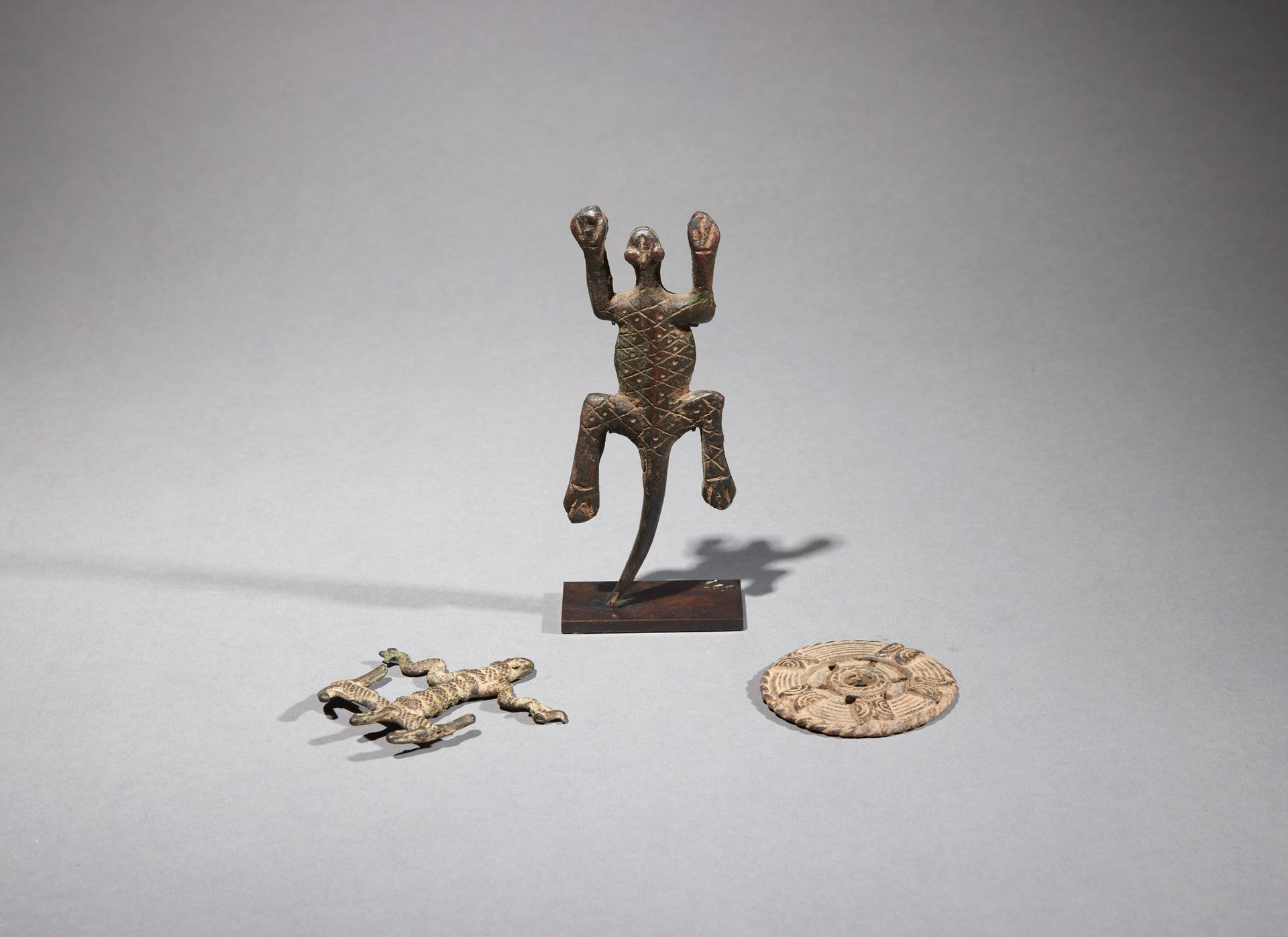 Null 三件人工制品

布基纳法索

铜质

长6至13.5厘米



一套三件青铜器，包括一只蜥蜴（尼日利亚），一个缠绕着蛇的Gan吊坠和一个装饰有几何图案&hellip;