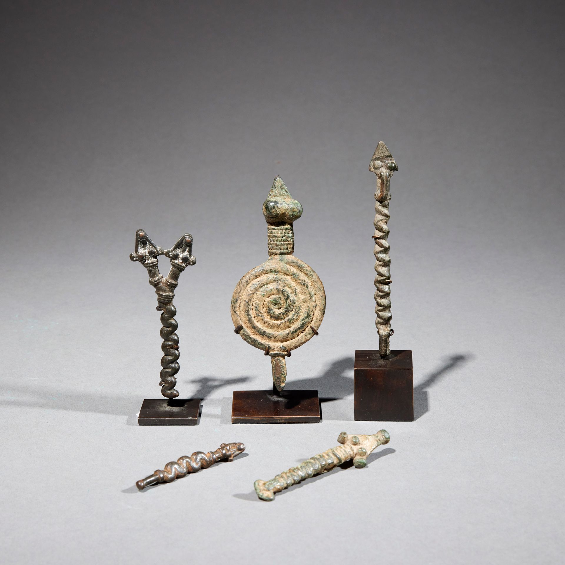 Null 五甘文物

布基纳法索

铜质

H.5.4至9.8厘米



一套四件描绘蛇的青铜甘器，其中一件是盘着的，一件有两个头。