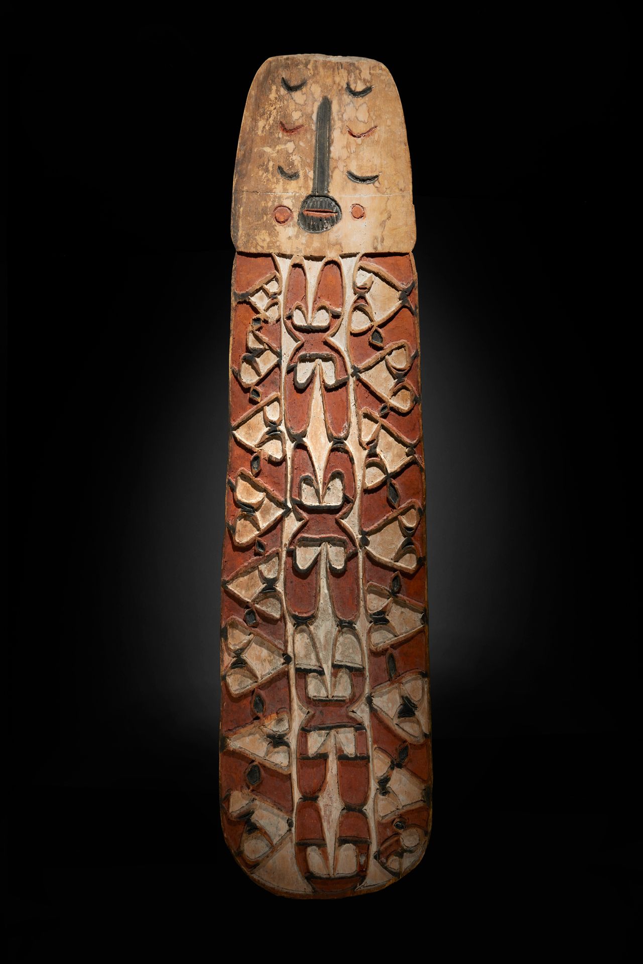 Null 阿斯玛特舞蹈盾牌

新几内亚

木材和颜料

H.150 cm - L. 37 cm



大盾牌的上部有一个面孔，并有经典风格的卷轴和几何图案的装饰&hellip;