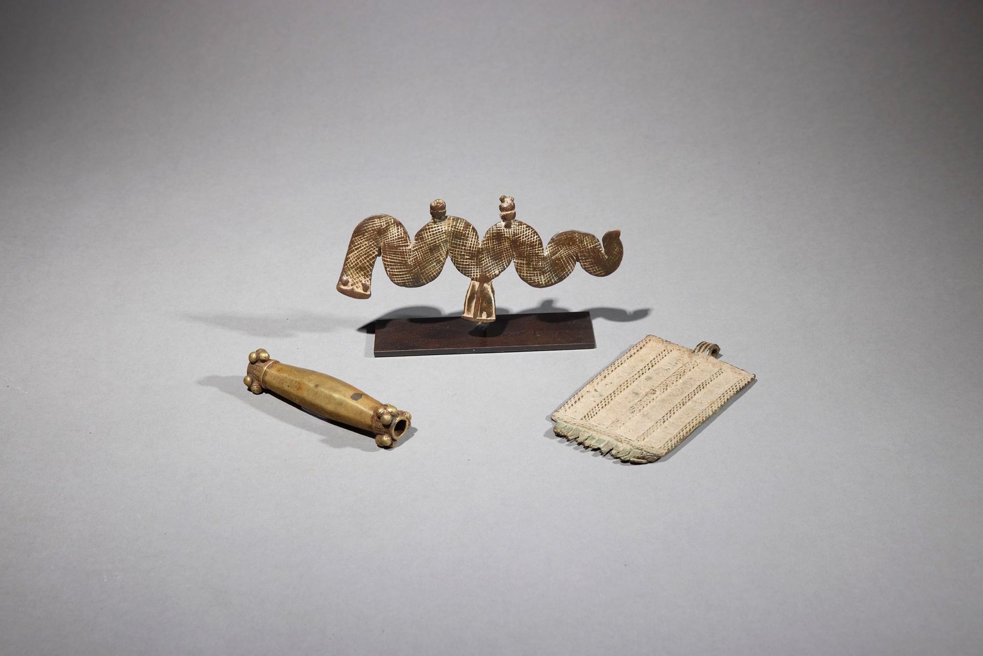 Null 三个装饰品

象牙海岸/布基那法索

铜质

长：9.7至11.1厘米



一套三件饰品，包括两个青铜吊坠，一个是蛇形的Lobi，另一个是四角形的，&hellip;