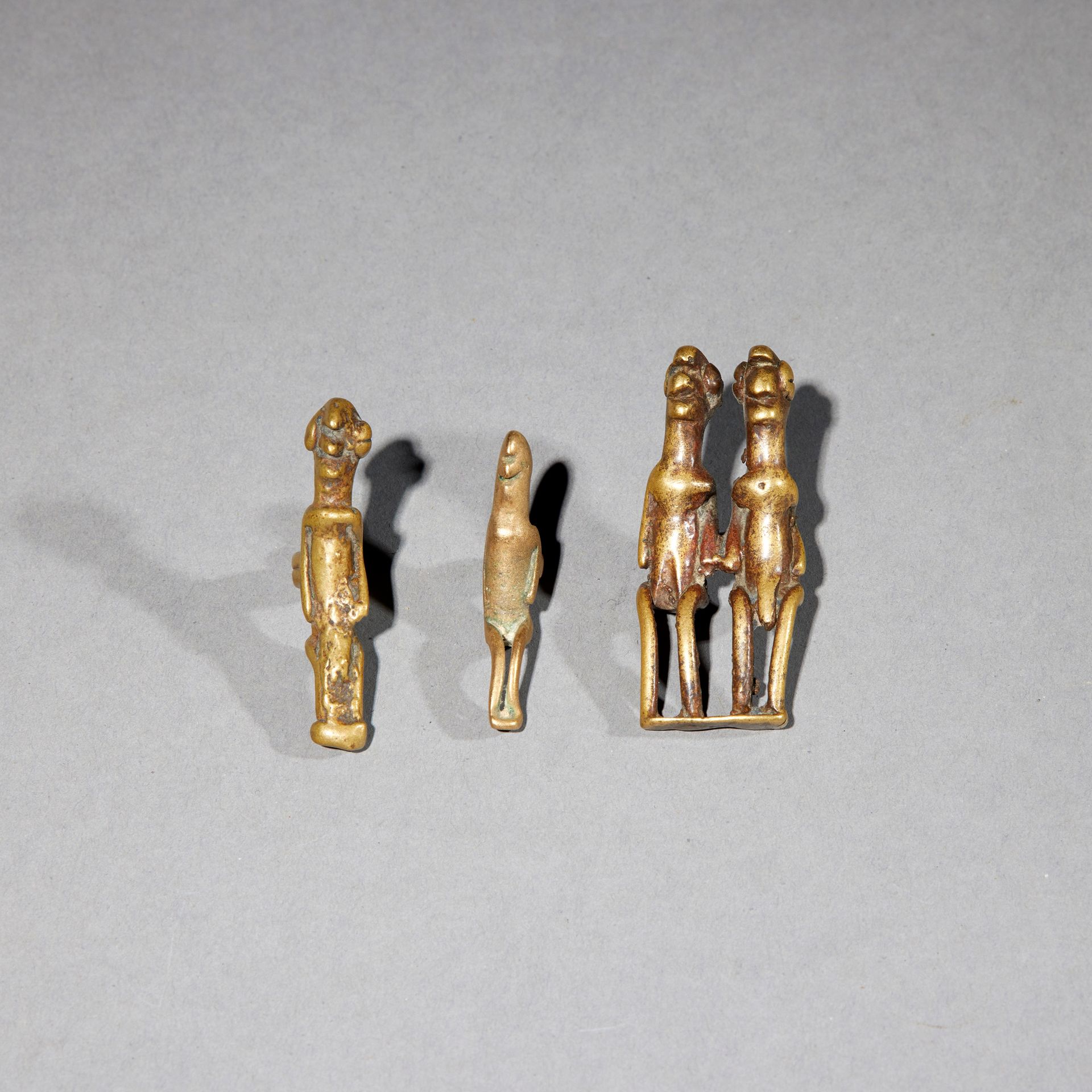 Null 三件Pwo文物

布基纳法索

铜质

H.4.1至5.2厘米



一套三件普沃青铜器人物，包括两个吊坠和一对夫妇。