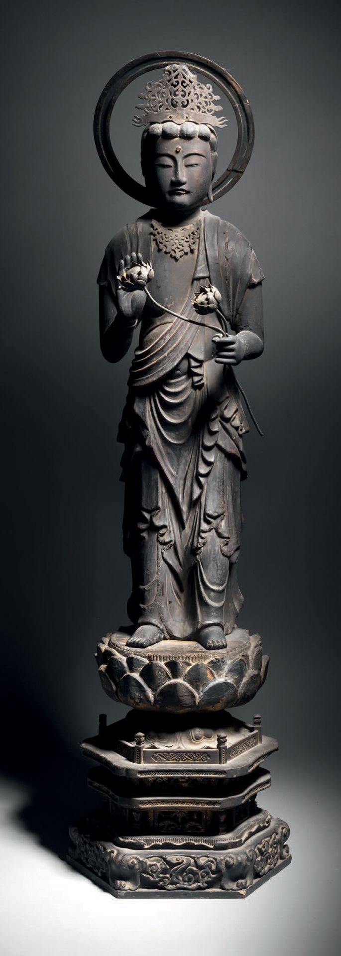 Null 观音菩萨，日本，约18世纪，高63厘米。漆面和镀金的木材
慈悲的菩萨站在一个以莲花为顶的宝座上。他身穿多褶的王子服装，右手做无畏的手势，左手拿着两朵莲&hellip;
