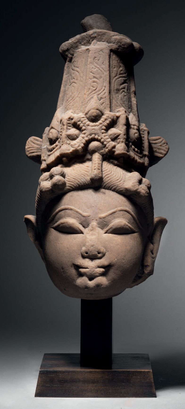 Null 男神头像，中印度，11-12世纪，高29.5厘米。米色砂岩
表情慈祥的神灵戴着雕刻精美的头饰，脸部圆润饱满，眼睛呈杏仁状，半闭着，眉毛呈弧形浮雕，嘴唇&hellip;