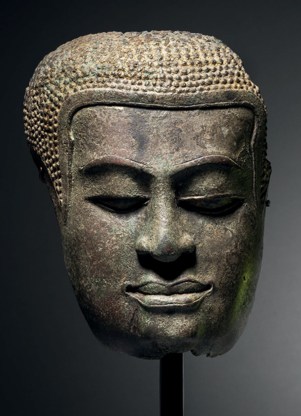 Null 佛像面具，泰国，Uthong B风格，14-15世纪，高14厘米。铜合金
在大城县时期的初期，高棉艺术仍然存在。佛祖的面容很安详，眼睛半闭成杏仁状，性&hellip;