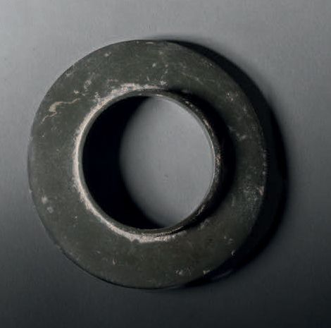 Null 手镯，泰国，班清文化，约公元前2000年，直径10.4厘米。石头
灰绿色的圆盘手镯，部分被凝结物覆盖。